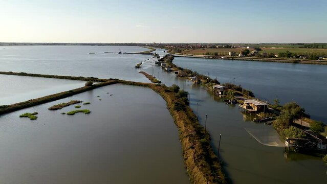Aerial view of fishing lodges mounted on poles in the water, Comacchio Lagoon On Sunset, Northern Italy