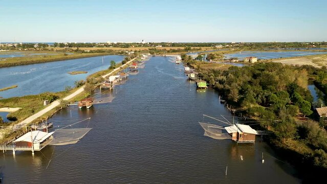 Aerial view of fishing lodges mounted on poles in the water, Comacchio Lagoon On Sunset, Northern Italy
