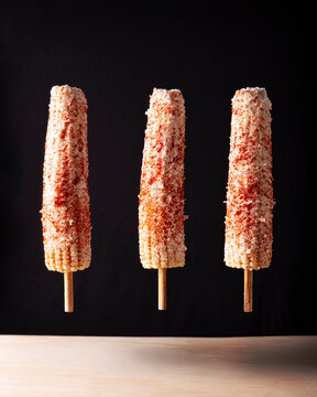 Elotes Callejeros are a popular street snack in Mexico, it is tender corn cooked with spices, skewered on a wooden stick covered with mayonnaise or sour cream, fresh cheese and piquin chili powder.