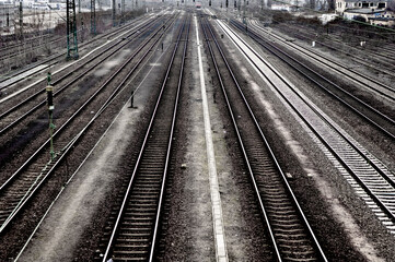 Die parallel zulaufenden Gleise einer Eisenbahnstrecke in Schwarzweiß