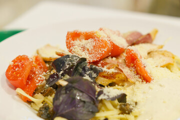 A plate of Italian tasty pasta with cheese, tomatoes, and sauce. Meal. Mushroom. Nourishment. Parmesan. Parmesan. Pasta. Plate. Ready-to-eat. Recipe. Restaurant. Sauce. Spaghetti. Substance