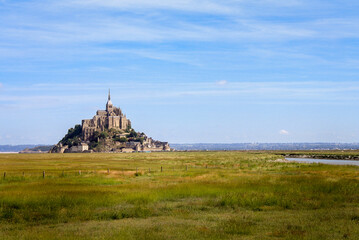 Beautiful panoramic view of famous Le Mont Saint-Michel tidal island with blue sky. Normandy, northern France