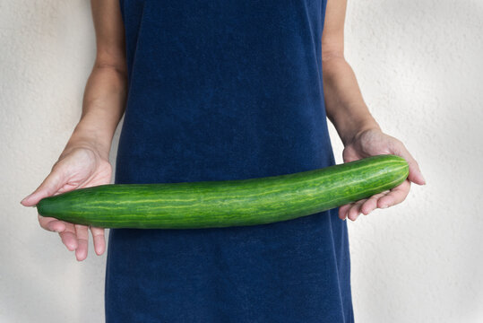 Woman holding huge seedless cucumber