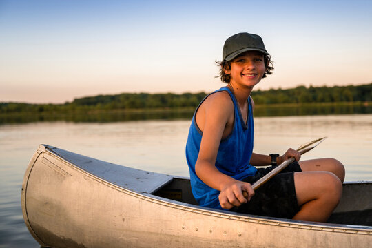 Air Force service member takes his sons canoeing at sunset out on the lake.