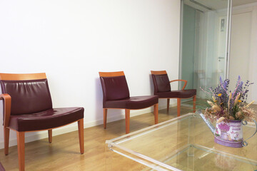 Chairs in empty dentist waiting room with jar of flowers