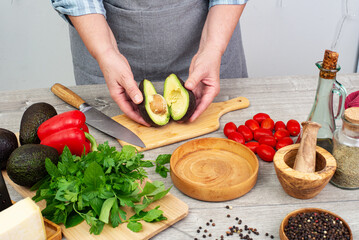 cook woman hands preparing avocado for serving.