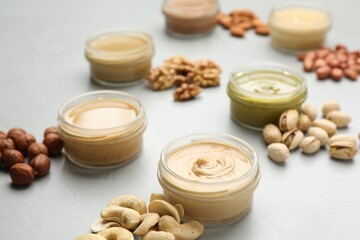 Different types of delicious nut butters and ingredients on light table