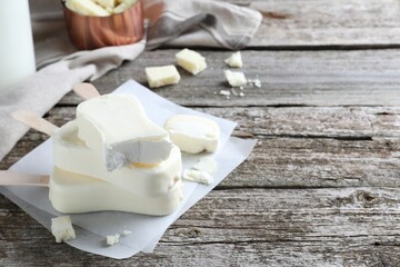 Delicious glazed ice cream bars on wooden table. Space for text