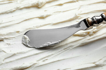 Tasty cream cheese and knife, closeup view