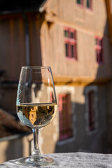 Tasting of white grand cru classe chablis wine with old French houses on background, Burgundy, France