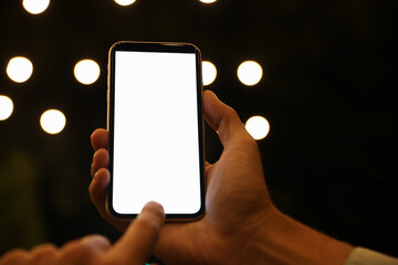 Man using modern mobile phone outdoors at night, closeup