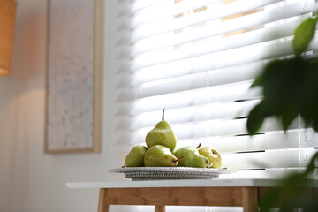 Fresh ripe pears on white table in room