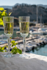 Two glasses of French champagne sparkling wine and view on colorful fisherman's boats in old harbour in Cassis, Provence, France