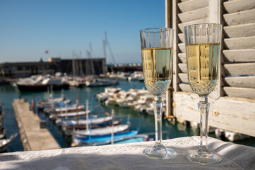 Two glasses of French champagne sparkling wine and view on colorful fisherman's boats in old harbour in Cassis, Provence, France