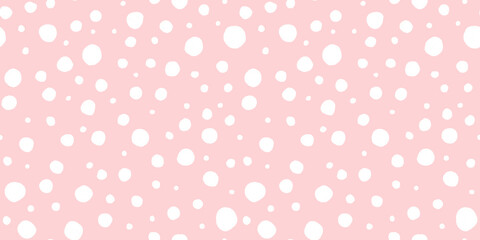 Seamless playful hand drawn light pink and white polka dot, snow or animal spots fabric pattern. Abstract geometric circle background texture. Girls birthday, baby shower or nursery wallpaper design.