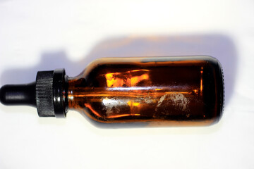 A glass bottle with a plastic cap and a small dropper to take the liquid or contents in the bottle.