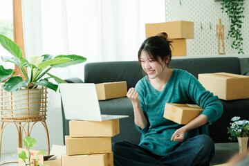 Fototapeta na wymiar Young happy asian SME business woman use digital checking customer order.