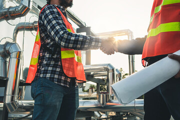 Hanshake seals an agreement at construction site. Architect and worker handshaking on construction site. building, teamwork, partnership, gesture and people concept.