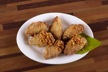 golden yellow fried chicken wings in white plate,Include Clipping Path.
