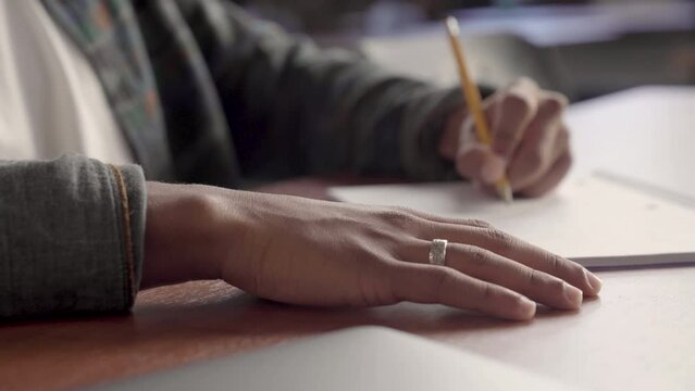 Young Indigenous man taking notes in class