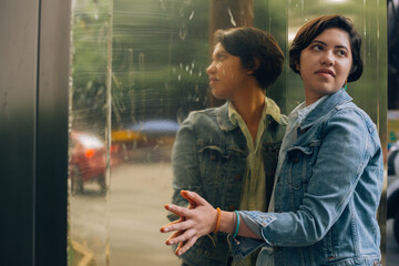 Pretty and cheerful young generation z girl with short hair dressed in blue with a denim jacket,...