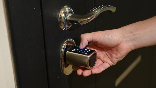 A woman closes the combination lock on the door to the apartment. Keyless Entry. 