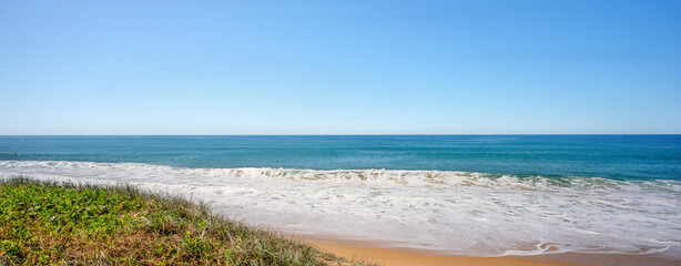 Foam from backwash from ocean waves breaking onto a sandy beach at Buddina, Queensland.