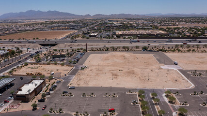 Afternoon aerial view of new shopping mall sprawl and empty lots of downtown Goodyear, Arizona, USA.