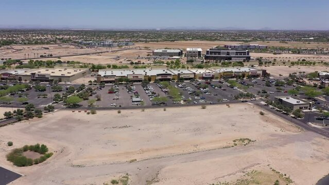 Afternoon aerial view of new shopping mall sprawl and empty lots of downtown Goodyear, Arizona, USA.
