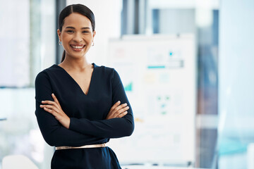Confident, happy and smiling business woman standing with her arms crossed while in an office with...