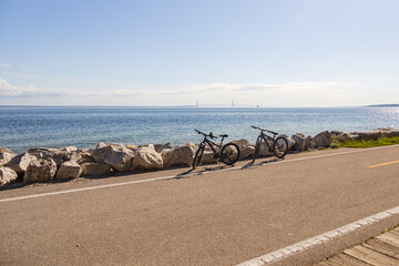 Fototapeta na wymiar Two bicycles parked on the side of the road with Mackinac Bridge in background