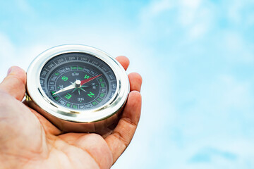 Hand holding a compass ready for a holiday adventure trip, it tells the direction north, south, east, west.