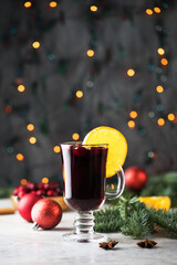 Fototapeta na wymiar Glasses of mulled wine with cranberries and a cinnamon stick on a Christmas background with bokeh.