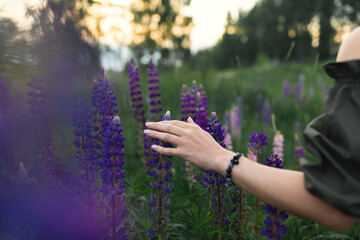 An attractive woman in a field with a summer bouquet of wildflowers Lupinus. Front view.