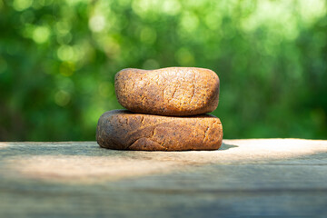 pieces of cannabis hashish with high thc closeup on nature green background.