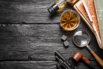 Whiskey in the drinking glass on the detective desk table background concept. Top view.