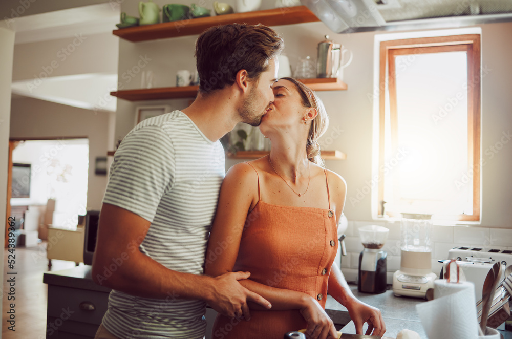 Sticker Romantic couple kissing, cooking and showing affection in love while bonding together in a kitchen at home. Caring boyfriend and girlfriend in a loving relationship sharing an intimate special moment