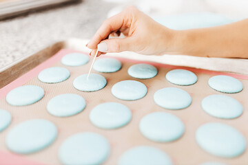 The process of making macaroons. Cookie baking. A woman prepares macaroons for baking. Blue...