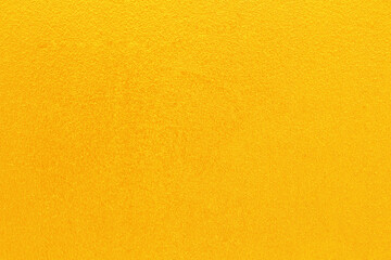 Gold or yellow paint on cement wall texture  background.