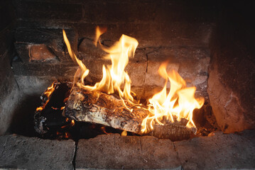 Burning fire in the brick fireplace background. Front view.