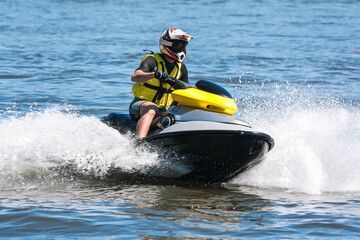 Fototapeta na wymiar man running a jet ski in the waves with water splash