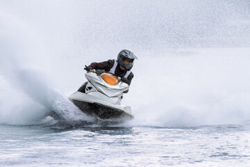 fast jet ski racer drives watercraft. high speed with water spray.