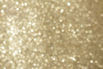Abstract golden bokeh background, defocused blurry sparkles.