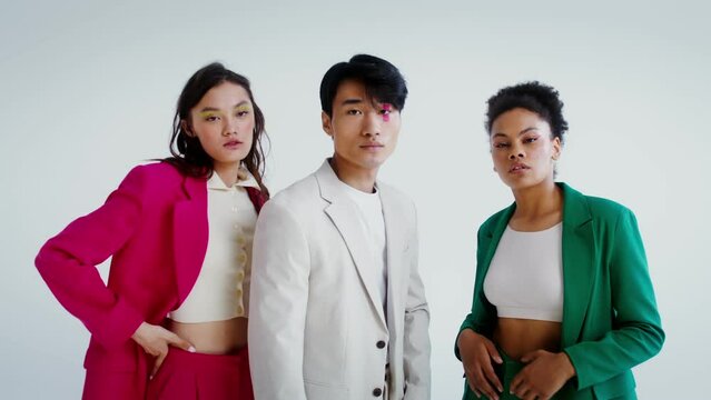 Man and two women posing on a white background in the studio