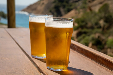 Two glasses of fresh cold lager beer served outdoor in snack bar with view on Calanque de...