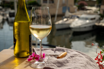 Drinking of cold white wine  with view on yacht harbour of Port Grimaud, summer vacation on French Riviera, France