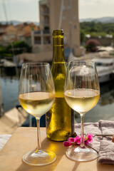 Drinking of cold white wine  with view on yacht harbour of Port Grimaud, summer vacation on French Riviera, France