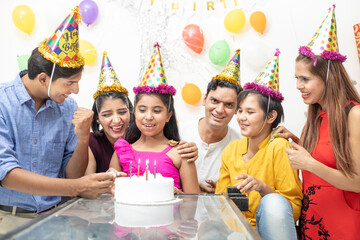 Happy Indian asian family or friends celebrate birthday. Eat cake, holidays and people concept.