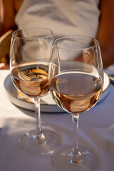 Dinner at sunset in French restaurant with cold dry rose wine in Port Grimaud, summer vacation on French Riviera, France