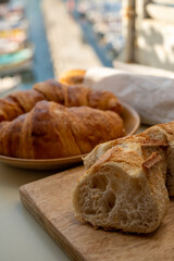 Morning in summer Provence, breakfast with fresh baked croissants and baquett bread and view on fisherman's boats in harbour of Cassis, Provence, France